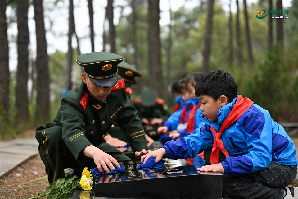 圖6：2026年3月26日，安徽肥東，在安徽省肥東縣茶壺山烈士陵園，武警官兵與學(xué)生擦拭烈士墓碑上灰塵，緬懷先烈。